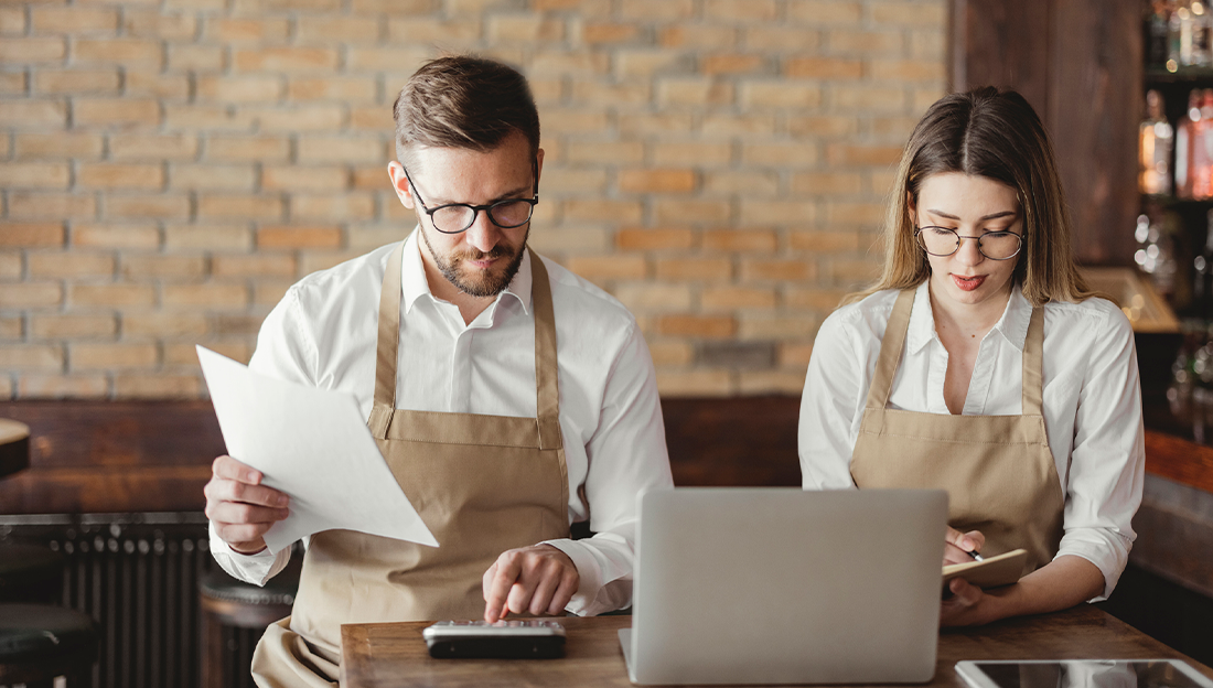 Dos empleados de un restaurante haciendo un balance de los costos