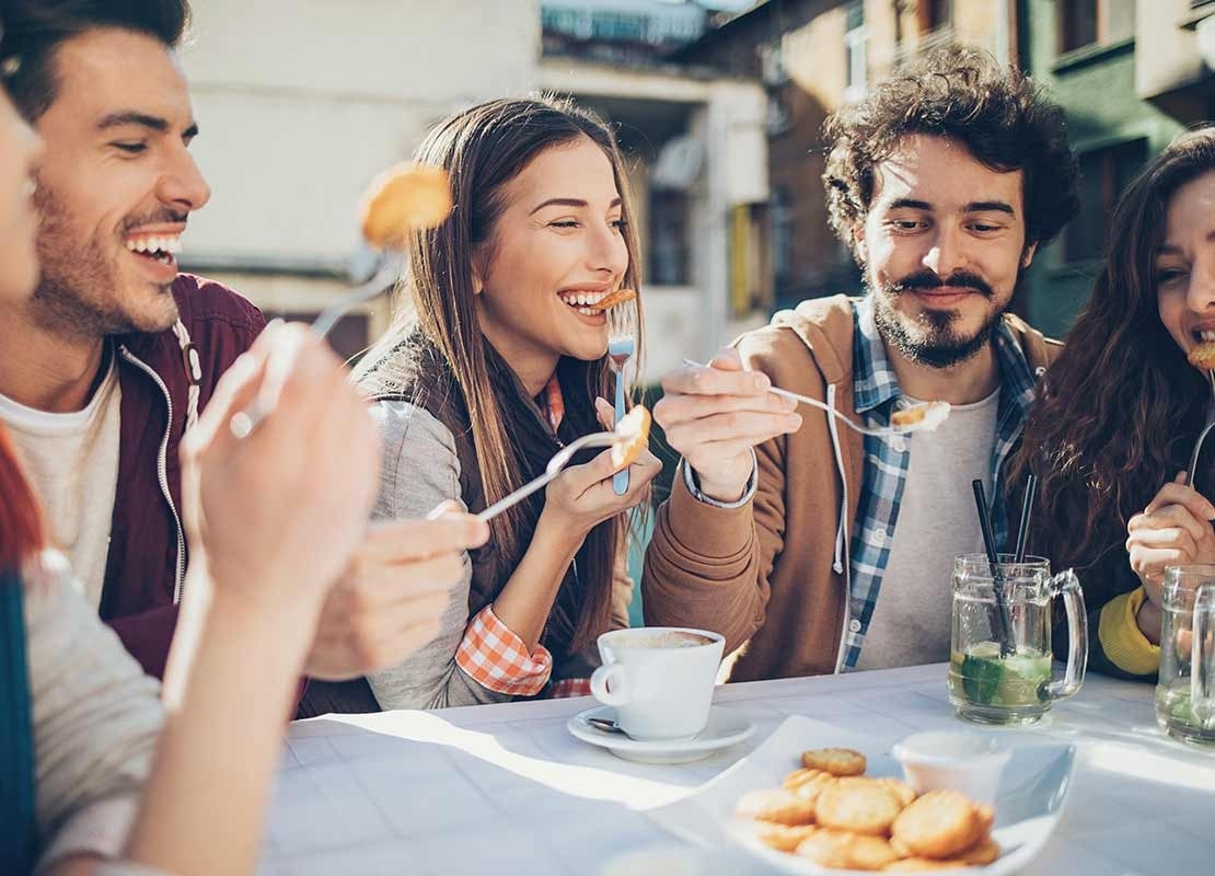 Compañeros de trabajo comparten alimentos y café en espacio de coffee break al aire libre