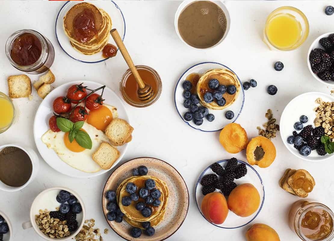Ideas para brunch clásicas incluyen cereal, huevos, mermelada, fruta, pancakes y más comidas