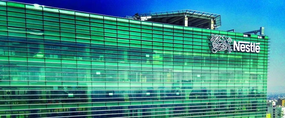Edificio de cristales verdes con el logotipo de la compañía NESTLÉ®