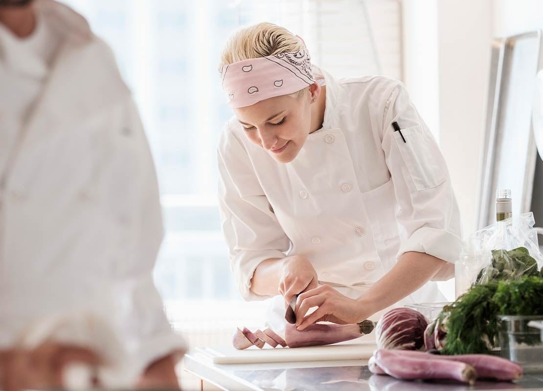 Chef profesional realizando tipos de corte en la cocina con precisión y dedicación.
