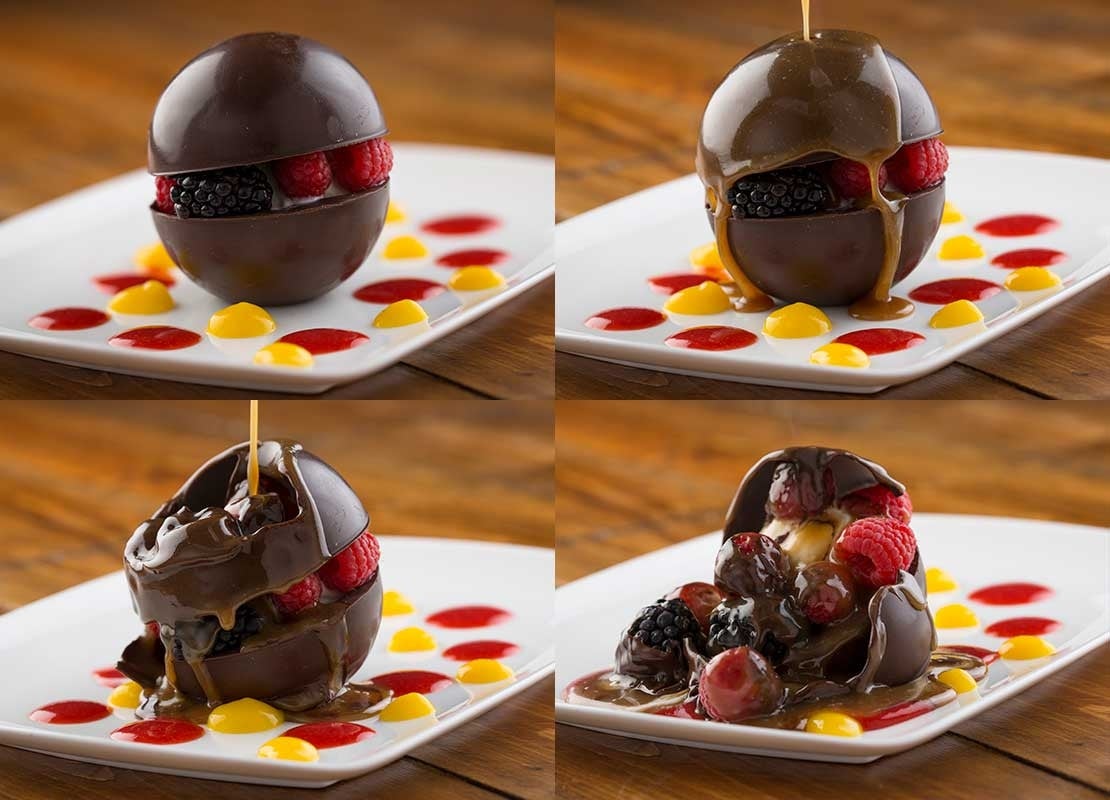 Secuencia de un postre esférico de chocolate relleno de frutas, que se derrite al verter salsa caliente