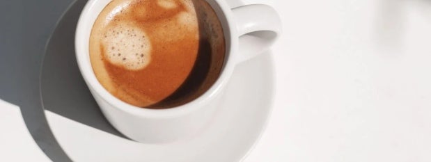 Taza blanca de café elaborada con NESCAFÉ® y COFFE MATE®