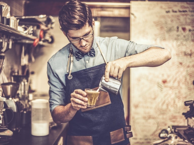 Joven barista preparando un café