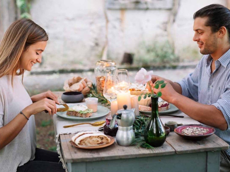 Pareja disfrutando de una cena romántica en un restaurante al aire libre