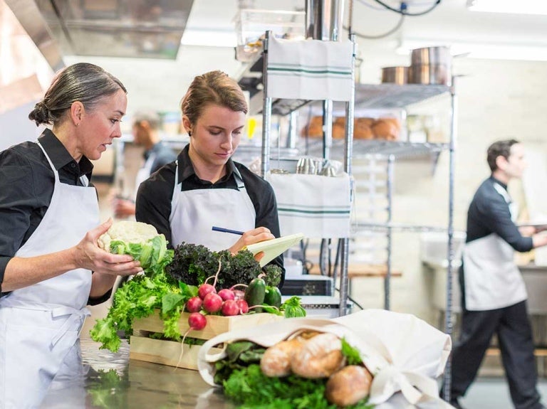 Dos chefs manipulan alimentos para verificar si son frescos, inocuos y de calidad
