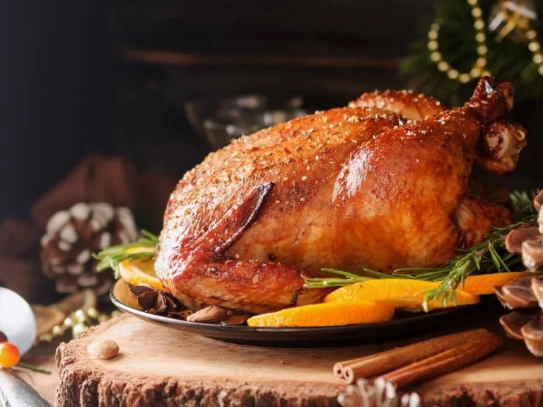 Pavo al horno para la cena de fin de año sobre una mesa temática decorada con elementos rústicos en restaurante