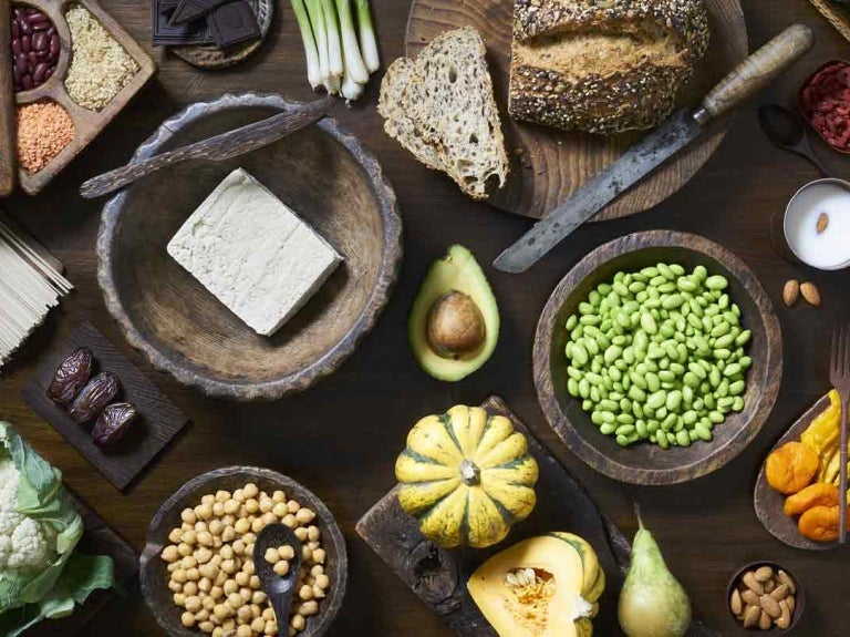 Verduras, frutas, legumbres y cereales en una mesa de madera