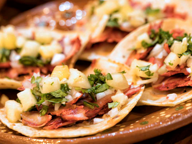 Tacos al pastor en una mesa, un famoso plato latinoamericano