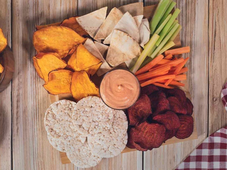 Chips de camote, remolacha, bastones de vegetales y salsa como snacks para cafetería