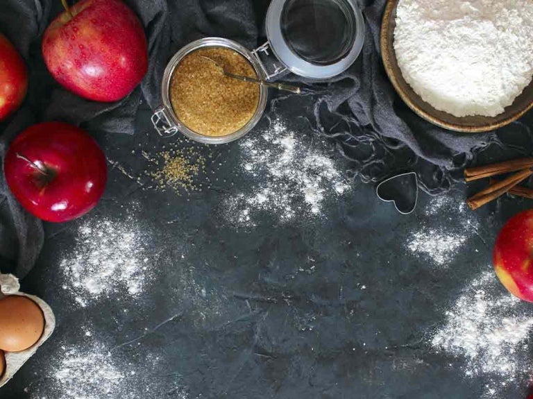 Manzanas, huevos, harina, azúcar, canela y otros insumos para repostería