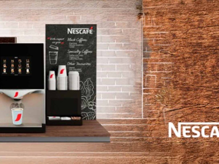 Máquina de café NESCAFÉ® en un cover con vasos, tapas, endulzantes y material POP