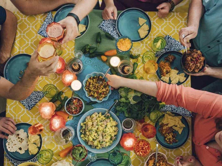 Grupo de personas celebra una fecha especial, comiendo y brindando a la mesa de un restaurante