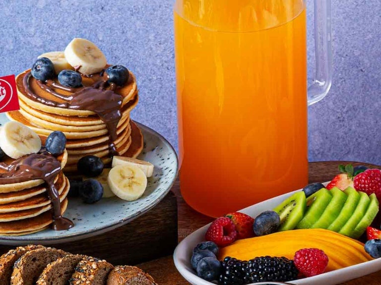 Desayuno con KITKAT® servido en diferentes platos, tazas, vasos y otras piezas de una vajilla