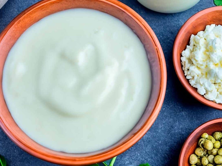 Cuencos con guisantes secos, yogur, requesón y una botella de bebida vegetal como sustitutos de la leche