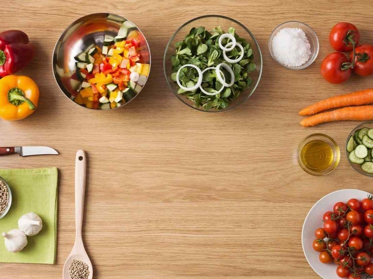 Mesa con ingredientes frescos y coloridos dispuestos ordenadamente para preparar un plato