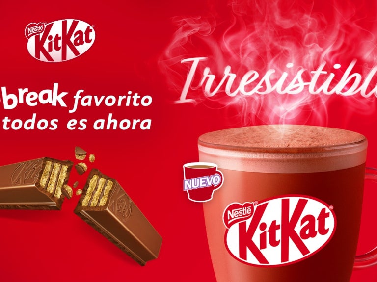 Banner KitKat Nestlé: taza roja con bebida caliente humeante y barra de chocolate KitKat con texto 'Irresistible'