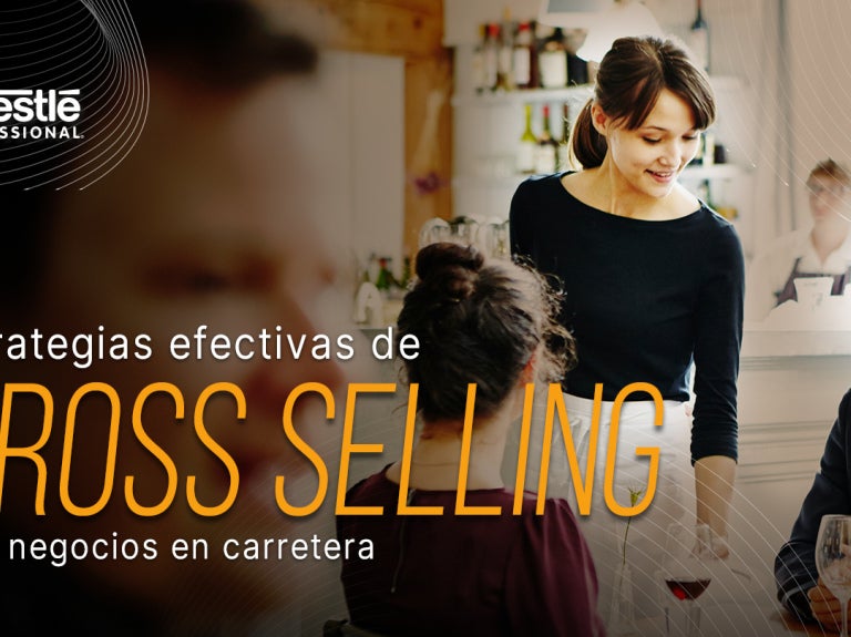 Mesera atendiendo a clientes en un restaurante mientras aplica estrategias de venta cruzada.