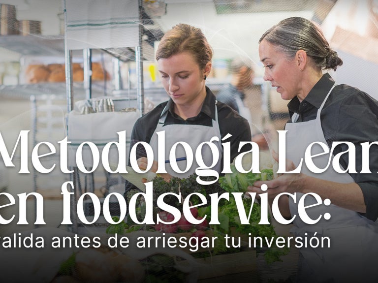 Dos personas revisan procesos en una cocina profesional, ilustrando la aplicación de metodología lean.