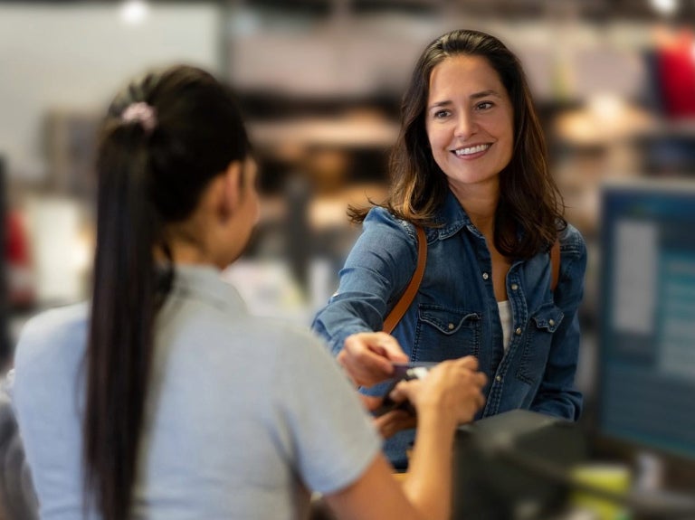Persona realizando un pago en mostrador mientras se gestiona el arqueo de caja en un negocio gastronómico.