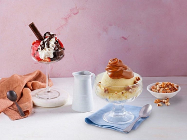 Vasos de helado con frutas, crema, chocolate y caramelo como opciones de toppings para helados