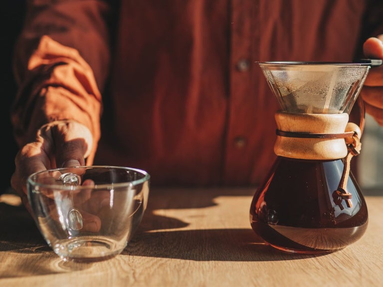 Barista prepara café filtrado con método manual tipo Chemex para una extracción limpia y aromática.