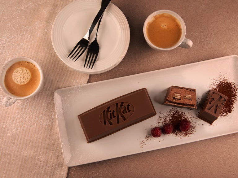 Postre de chocolate KITKAT® con café servido en platos blancos