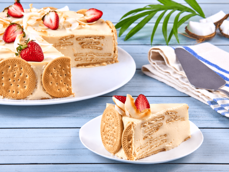 Rebanada de pastel de galleta y crema cubierto con fresas en un plato, elaborado con calidad IDEAL® professional.