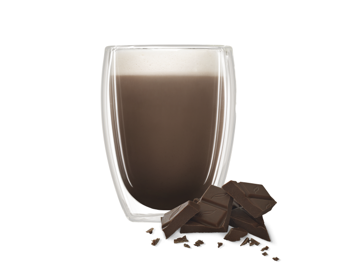 Vaso de vidrio de doble pared con bebida de chocolate junto a trozos de chocolate