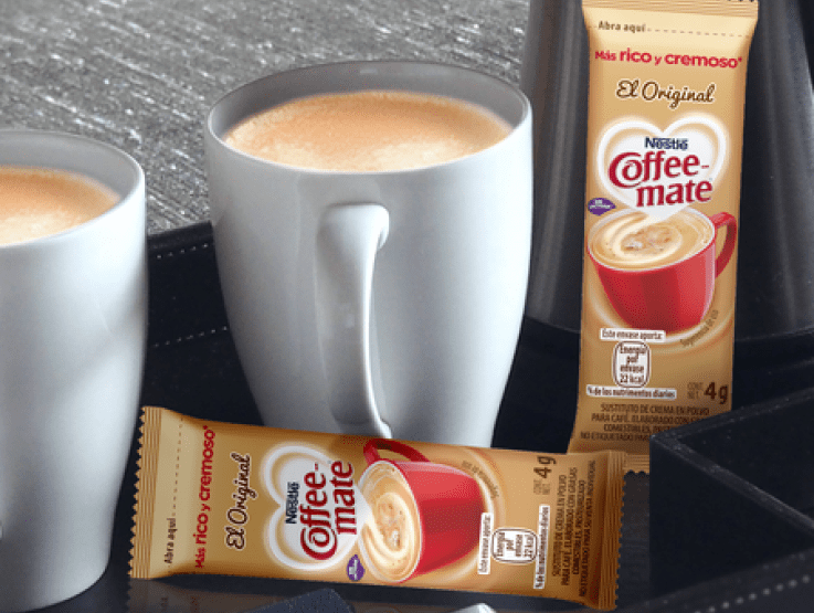 Dos sobres de Coffee-Mate Original junto a dos tazas de café