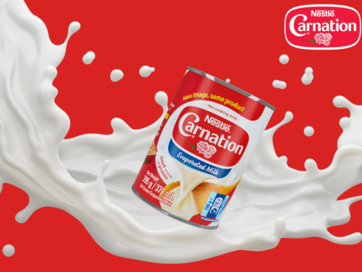 Una lata de leche evaporada profesional CARNATION® con un toque de leche sobre un fondo rojo vibrante.
