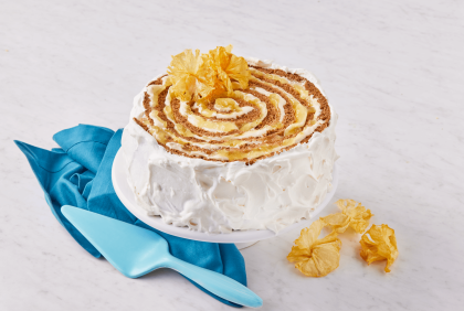 Un pastel en espiral con glaseado de tu proveedor de lácteos al por mayor, sobre un soporte con una servilleta azul.