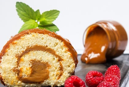 Una rebanada de pastel enrollado con relleno de caramelo. Postres elaborados con un proveedor de lácteos al por mayor.