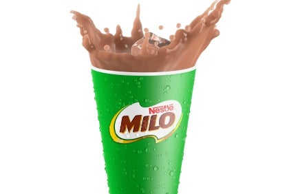 Bebida chocolatada con un hielo en un vaso verde con el logo de MILO® de NESTLÉ® hace splash