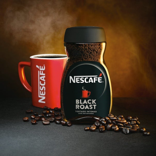 Taza roja de café Nescafé junto a un frasco de Nescafé Black Roast Tostado Intenso
