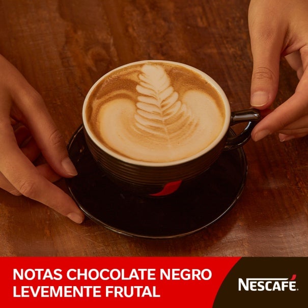 manos al rededor de taza nescafé 