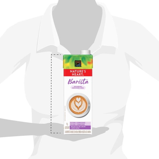 Una mujer sostiene una caja de bebida vegetal NATURE'S HEART® de 1L, reflejando el tamaño que tiene de alto el empaque.