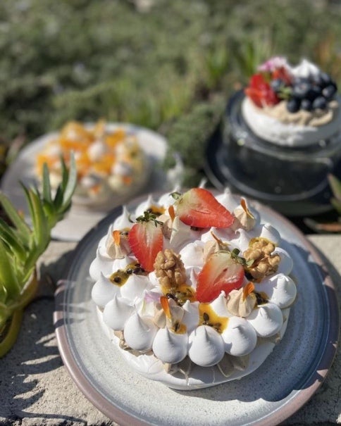 Torta de merengue decorada fresas, maracuyá y nueces