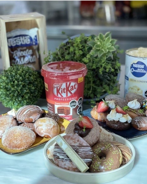 Donas Rellenas junto a un balde de Crema Untable KitKat, un Manjar Receta casera y una lata de Leche Condensada Untable