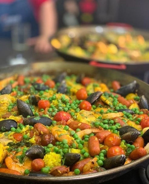 Platos de paella con mariscos, choricillos, pollo y arvejas