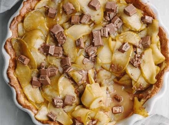 En un molde, Pie de Manzana decorado con trozos de KITKAT® 4 Finger