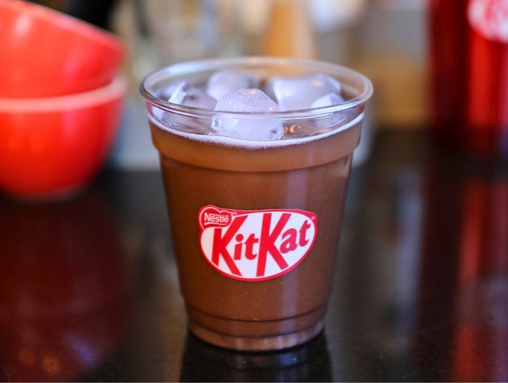 Vaso transparente con receta Iced KITKAT® sobre una mesa de una mesada