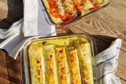 Dos refractarias con canelones de pollo y ricota, una con salsa de tomates y otra con salsa de queso