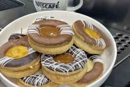 Bandeja con Galletas Linzer junto una taza blanca de Nescafé y una máquina de café