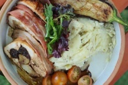 Plato con pechuga de pavo rellena acompañado de puré de berenjenas, salsa, tomates cherry y berenjenas asadas
