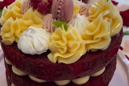 Torta red velvet con relleno cheesecake decorada con Leche Condensada Untable Nestlé, macarons y berries