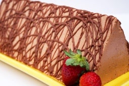 Terrina de chocolate con forma de prisma triangular, decorada con fresas y productos TRIÁNGULO®