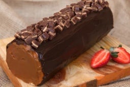 Pionono de chocolate decorado con trozos del producto en barra PRINCESA® y Manjar NESTLÉ®