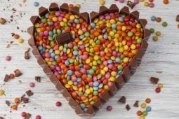 Torta de chocolate con LENTEJAS® Mini coloridas en forma de corazón sobre una mesa