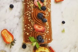 Brazo de Reina decorado con NESTLÉ® Manjar Dulce de Leche y frutas frescas como fresas y arándanos